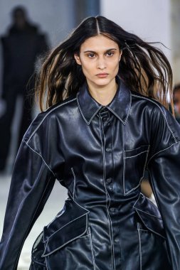 MILAN, ITALY - 26 Şubat 2022 'de Milano Moda Haftası / Kış 2023' te İtalya 'nın Milano kentinde düzenlenen Trussardi defilesinde bir model podyumda yürüyor..