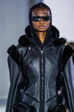 MILAN, ITALY - 26 Şubat 2022 'de Milano Moda Haftası / Kış 2023' te İtalya 'nın Milano kentinde düzenlenen Trussardi defilesinde bir model podyumda yürüyor..