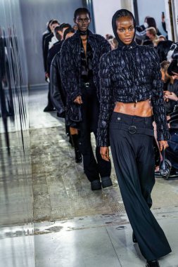 MİLAN, İTALYA - 26 Şubat 2022 'de Milano Moda Haftası / Kış 2023' te İtalya 'nın Milano kentinde düzenlenen Trussardi defilesinde mankenler podyum finalinde yürür..