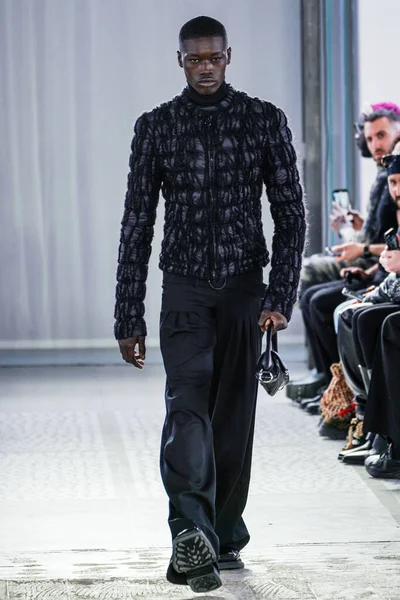 MILAN, ITALY - 26 Şubat 2022 'de Milano Moda Haftası / Kış 2023' te İtalya 'nın Milano kentinde düzenlenen Trussardi defilesinde bir model podyumda yürüyor..