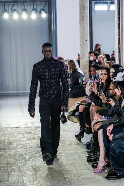 MILAN, ITALY - 26 Şubat 2022 'de Milano Moda Haftası / Kış 2023' te İtalya 'nın Milano kentinde düzenlenen Trussardi defilesinde bir model podyumda yürüyor..