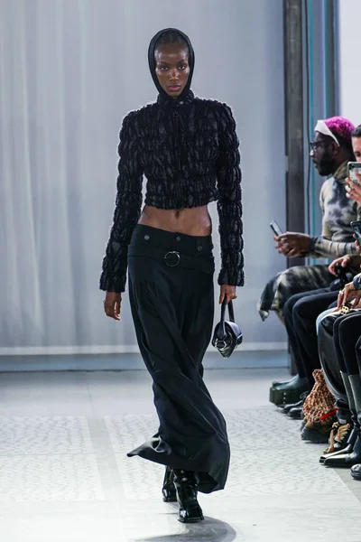 MILAN, ITALY - 26 Şubat 2022 'de Milano Moda Haftası / Kış 2023' te İtalya 'nın Milano kentinde düzenlenen Trussardi defilesinde bir model podyumda yürüyor..