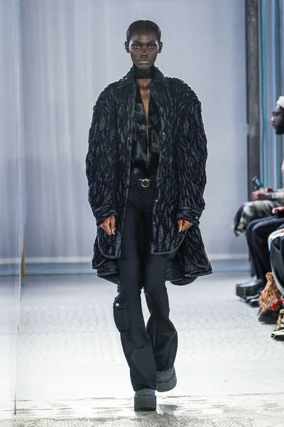 MILAN, ITALY - 26 Şubat 2022 'de Milano Moda Haftası / Kış 2023' te İtalya 'nın Milano kentinde düzenlenen Trussardi defilesinde bir model podyumda yürüyor..