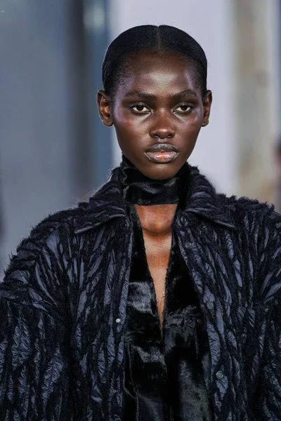 MILAN, ITALY - 26 Şubat 2022 'de Milano Moda Haftası / Kış 2023' te İtalya 'nın Milano kentinde düzenlenen Trussardi defilesinde bir model podyumda yürüyor..