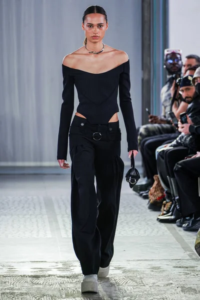 MILAN, ITALY - 26 Şubat 2022 'de Milano Moda Haftası / Kış 2023' te İtalya 'nın Milano kentinde düzenlenen Trussardi defilesinde bir model podyumda yürüyor..