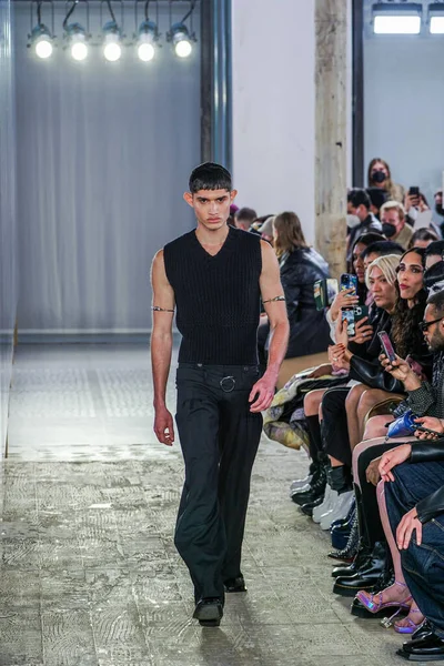 MILAN, ITALY - 26 Şubat 2022 'de Milano Moda Haftası / Kış 2023' te İtalya 'nın Milano kentinde düzenlenen Trussardi defilesinde bir model podyumda yürüyor..