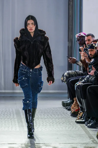 MILAN, ITALY - 26 Şubat 2022 'de Milano Moda Haftası / Kış 2023' te İtalya 'nın Milano kentinde düzenlenen Trussardi defilesinde bir model podyumda yürüyor..