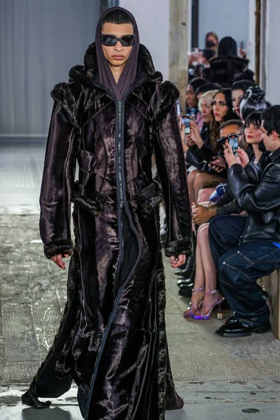 MILAN, ITALY - 26 Şubat 2022 'de Milano Moda Haftası / Kış 2023' te İtalya 'nın Milano kentinde düzenlenen Trussardi defilesinde bir model podyumda yürüyor..