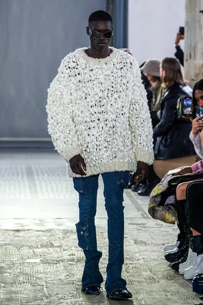 MILAN, ITALY - 26 Şubat 2022 'de Milano Moda Haftası / Kış 2023' te İtalya 'nın Milano kentinde düzenlenen Trussardi defilesinde bir model podyumda yürüyor..