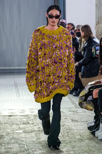 MILAN, ITALY - 26 Şubat 2022 'de Milano Moda Haftası / Kış 2023' te İtalya 'nın Milano kentinde düzenlenen Trussardi defilesinde bir model podyumda yürüyor..