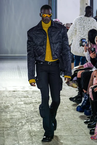 MILAN, ITALY - 26 Şubat 2022 'de Milano Moda Haftası / Kış 2023' te İtalya 'nın Milano kentinde düzenlenen Trussardi defilesinde bir model podyumda yürüyor..