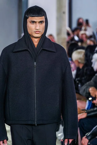 MILAN, ITALY - 26 Şubat 2022 'de Milano Moda Haftası / Kış 2023' te İtalya 'nın Milano kentinde düzenlenen Trussardi defilesinde bir model podyumda yürüyor..