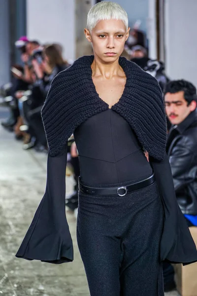 MILAN, ITALY - 26 Şubat 2022 'de Milano Moda Haftası / Kış 2023' te İtalya 'nın Milano kentinde düzenlenen Trussardi defilesinde bir model podyumda yürüyor..