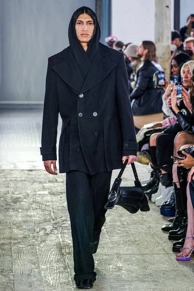 MILAN, ITALY - 26 Şubat 2022 'de Milano Moda Haftası / Kış 2023' te İtalya 'nın Milano kentinde düzenlenen Trussardi defilesinde bir model podyumda yürüyor..