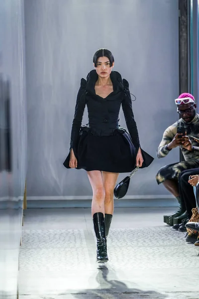 MILAN, ITALY - 26 Şubat 2022 'de Milano Moda Haftası / Kış 2023' te İtalya 'nın Milano kentinde düzenlenen Trussardi defilesinde bir model podyumda yürüyor..