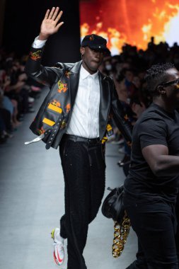 MILAN, İtalya - 26 Şubat 2022 tarihinde Milano, İtalya 'da düzenlenen Milan Moda Haftası / Kış 2023 sırasında Tokyo James defilesinde tasarımcı ve model podyum finalinde yürür..