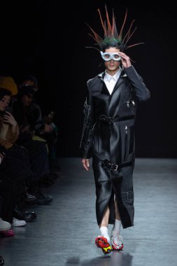MILAN, ITALY - 26 Şubat 2022 'de Milano Moda Haftası / Kış 2023' te Tokyo James defilesinde bir model podyumda yürüyor..