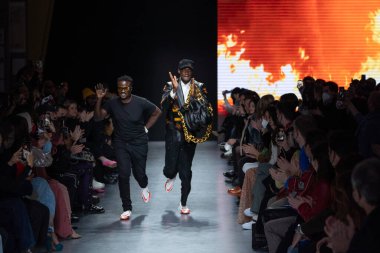 MILAN, İtalya - 26 Şubat 2022 tarihinde Milano, İtalya 'da düzenlenen Milan Moda Haftası / Kış 2023 sırasında Tokyo James defilesinde tasarımcı ve model podyum finalinde yürür..