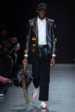 MILAN, ITALY - 26 Şubat 2022 'de Milano Moda Haftası / Kış 2023' te Tokyo James defilesinde bir model podyumda yürüyor..