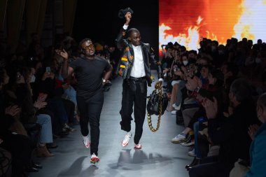 MILAN, İtalya - 26 Şubat 2022 tarihinde Milano, İtalya 'da düzenlenen Milan Moda Haftası / Kış 2023 sırasında Tokyo James defilesinde tasarımcı ve model podyum finalinde yürür..