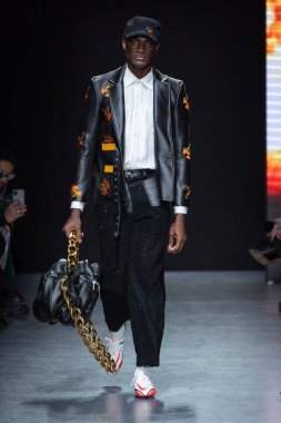 MILAN, ITALY - 26 Şubat 2022 'de Milano Moda Haftası / Kış 2023' te Tokyo James defilesinde bir model podyumda yürüyor..