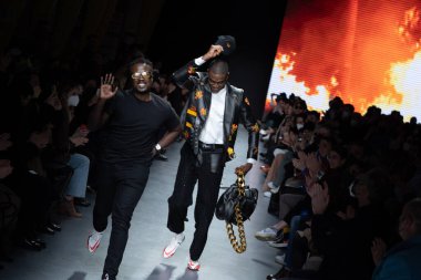 MILAN, İtalya - 26 Şubat 2022 tarihinde Milano, İtalya 'da düzenlenen Milan Moda Haftası / Kış 2023 sırasında Tokyo James defilesinde tasarımcı ve model podyum finalinde yürür..