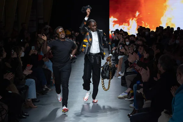 MILAN, İtalya - 26 Şubat 2022 tarihinde Milano, İtalya 'da düzenlenen Milan Moda Haftası / Kış 2023 sırasında Tokyo James defilesinde tasarımcı ve model podyum finalinde yürür..