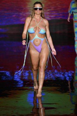 MIAMI BEACH, FLORIDA - 09 Temmuz 2021 'de Miami Beach, Florida' da bir model, Miami Swimwear Show 'da, Art Hearts tarafından desteklenen yüzme haftasında podyumda yürüyor..