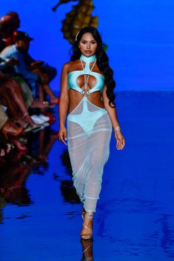 MIAMI BEACH, FLORIDA - 08 Temmuz 2021 'de Miami Beach, Florida' da düzenlenen Miami Swimwear Show 'da bir manken podyumda yürüyor..