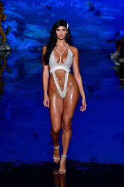 MIAMI BEACH, FLORIDA - 08 Temmuz 2021 'de Miami Beach, Florida' da düzenlenen Miami Swimwear Show 'da bir manken podyumda yürüyor..
