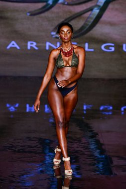 MIAMI BEACH, FLORIDA - 08 Temmuz 2021 'de Miami Beach, Florida' da düzenlenen Sharnel Guy Yüzme Gösterisinde bir model podyumda yürüyor..