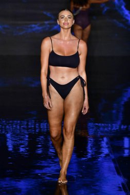 MIAMI BEACH, FLORIDA - 09 Temmuz 2021 'de Miami Beach, Florida' da düzenlenen Miami Yüzme Haftası sırasında Indigo Wild Swim Show 'da bir model podyumda yürüyor..