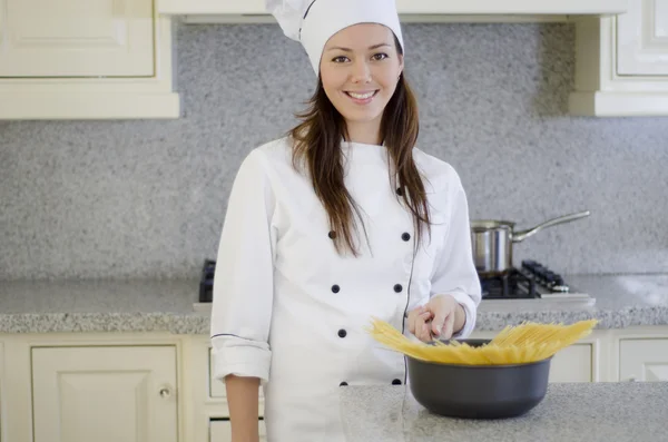 Vackra unga kvinnan matlagning spaghetti — Stockfoto