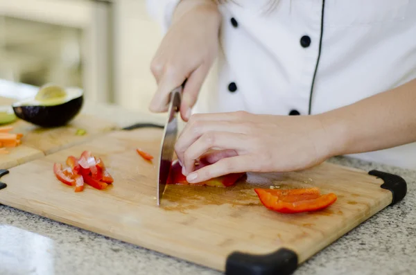 Жінка працює на кухні, ріжучи овочі — стокове фото