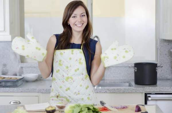 Schöne Brünette, die in der Küche arbeitet und glücklich aussieht — Stockfoto