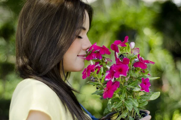 Güzel çiçek kokulu bir genç kadının portresi. — Stok fotoğraf