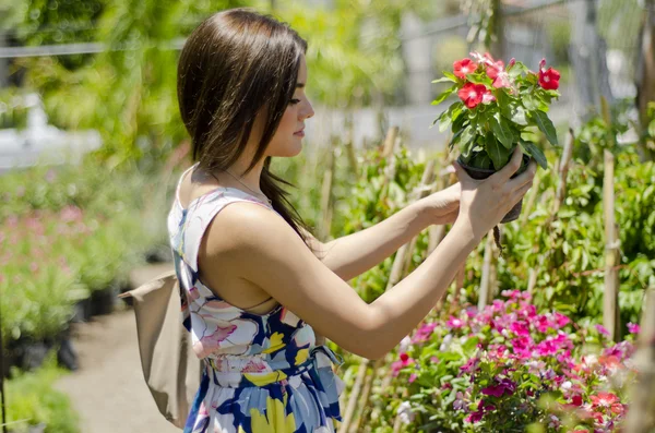 Retrato de cerca de una linda joven con flores sonriendo en el huerto —  Fotos de Stock