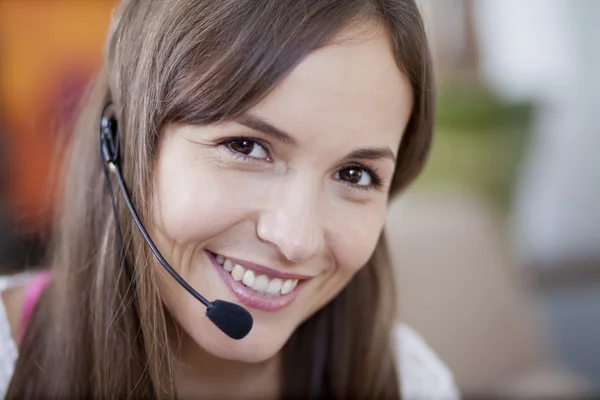 Bilden av ganska leende kvinna med headset ser fram — Stockfoto