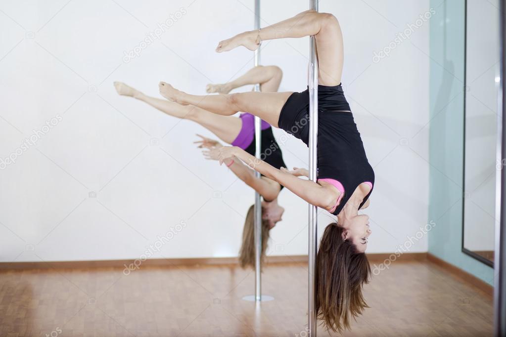 Young sexy women exercise pole dance