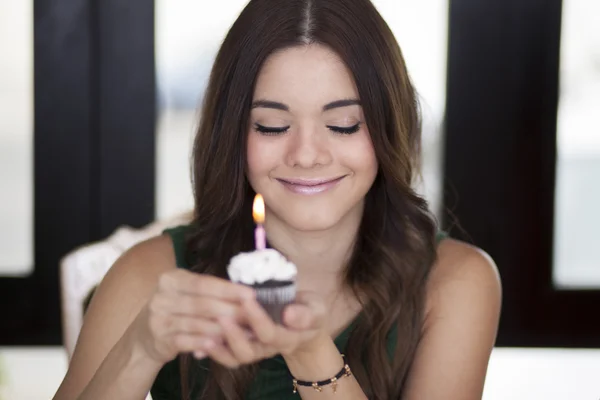 Una bella donna tiene il suo cupcake di compleanno — Foto Stock