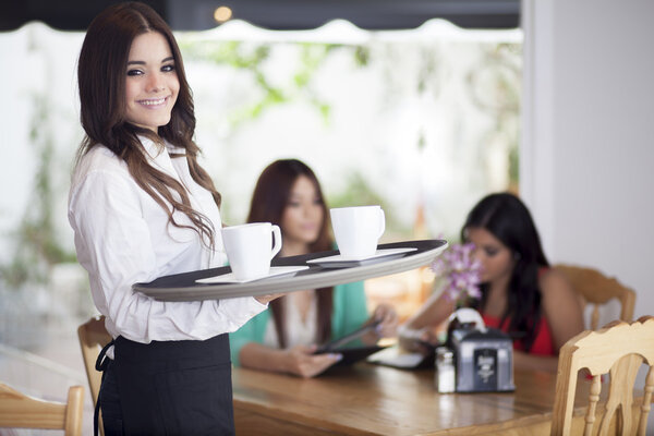 Portrait of young waitress holding a tray