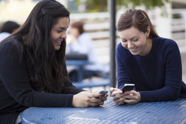 Meninas sorridentes com telefones celulares — Fotografia de Stock