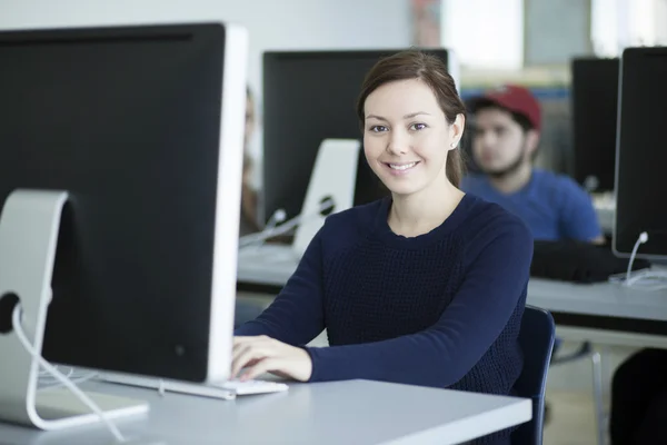 Sorridente giovane donna che lavora su un computer — Foto Stock