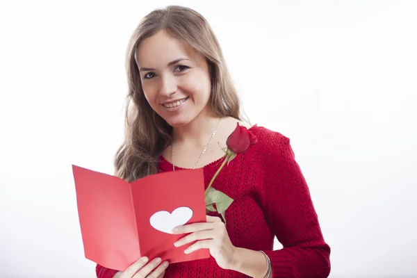 Güzel bir genç kadın kalp ile Sevgililer günü kart tutan gülümseyerek — Stok fotoğraf
