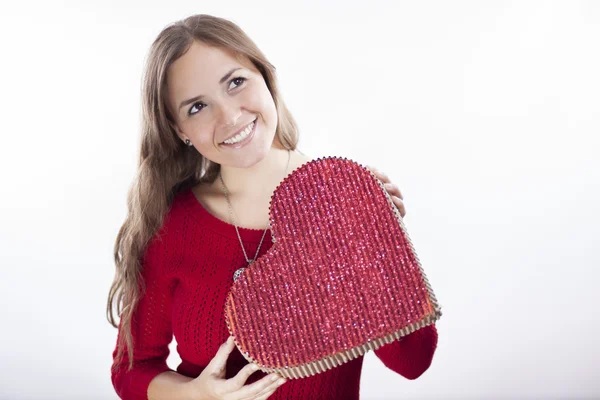 Cute young woman holds a heart symbol — Stock Photo, Image