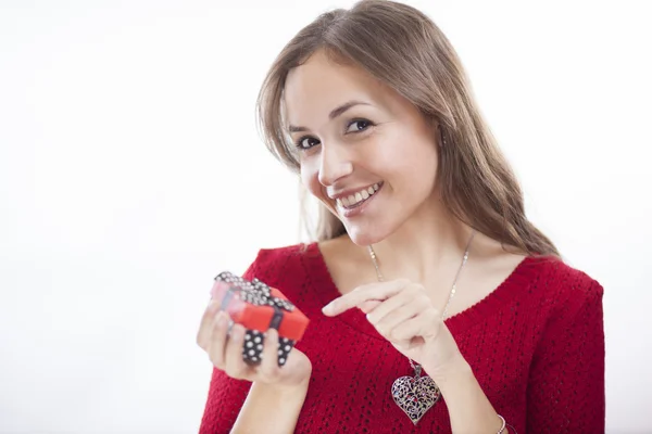 Woman in red sweater holding a gift on the day of St. Valentine — Stock Photo, Image
