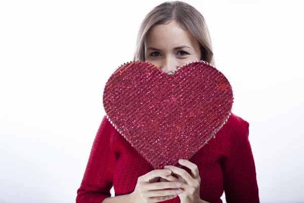 Cute young woman holds a heart symbol — Stock Photo, Image