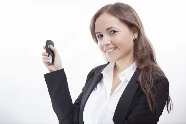 Business woman holding remote control — Stock Photo, Image