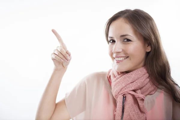Cute young woman pointing up at copy space — Stock Photo, Image