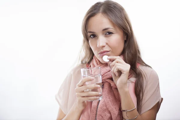 Donna con un bicchiere d'acqua e la compressa — Foto Stock